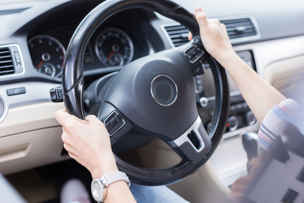 partial view of woman with hands on steering wheel driving car - Foto, Imagen