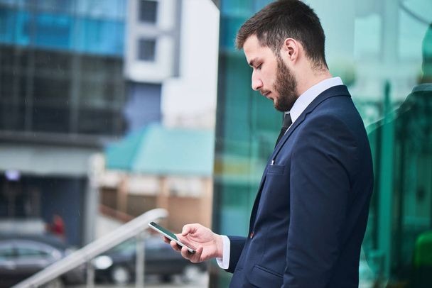 bearded businessman in suit using smartphone outdoor, close-up  - Photo, Image