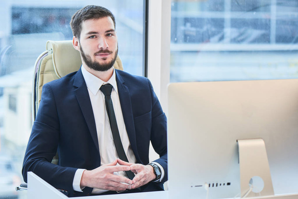 handsome bearded businessman sitting at table with computer in office  - Photo, Image