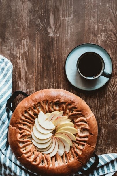 top view of homemade apple pie and cup of coffee on wooden tabletop - Фото, зображення