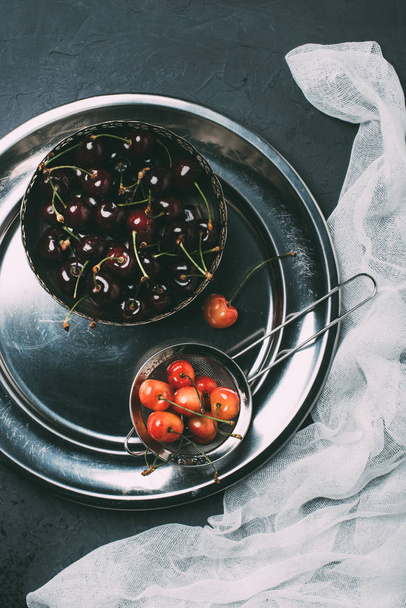 top view of fresh ripe sweet cherries in shiny metal plate   - Foto, immagini