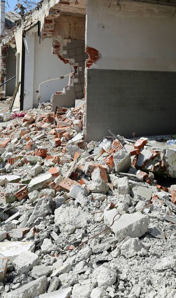 поврежденное здание со сломанными стенами и множеством кирпичей на земле
 - Фото, изображение