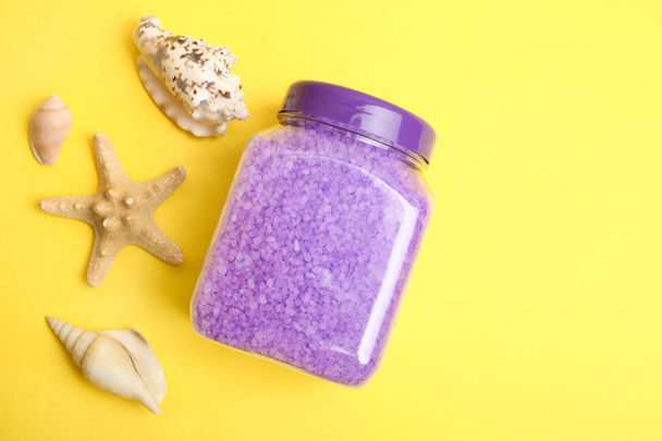 Purple sea salt in a jar and seashells on a yellow background. - Photo, Image