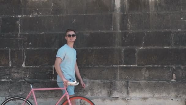 Genç bisikleti duvarının yakınında ile yürüyor - Video, Çekim