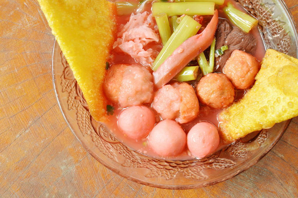 peixe cozido e bola de camarão cobertura de choco em conserva em sopa de molho de soja vermelha na tigela
 - Foto, Imagem