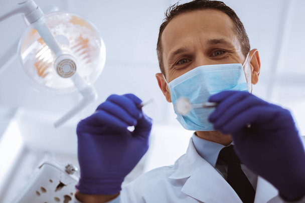 Portrait of handsome dentist while working - Photo, image
