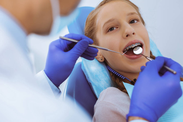 Competent dentist treating little patient - Photo, Image
