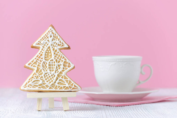 albero di Natale pan di zenzero sul cavalletto pittura con tazza di caffè su sfondo rosa
 - Foto, immagini