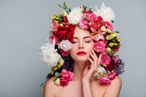portrait of beautiful naked woman with closed eyes posing in floral wreath isolated on grey  - Фото, изображение
