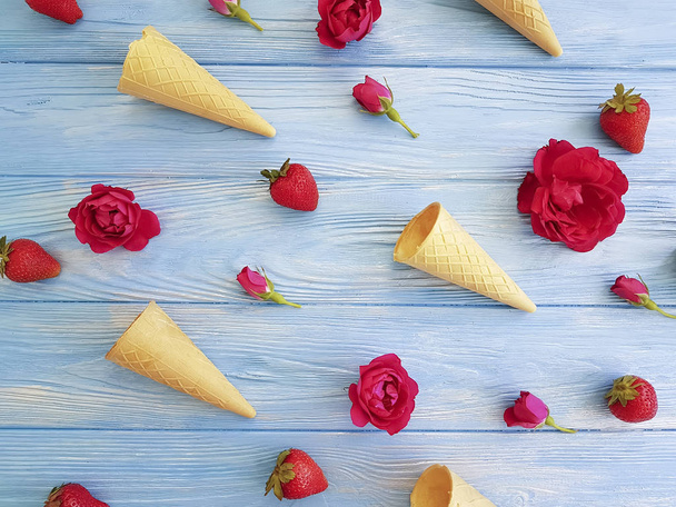 cone for ice cream, strawberry, rose flower pattern on a blue wooden - Φωτογραφία, εικόνα
