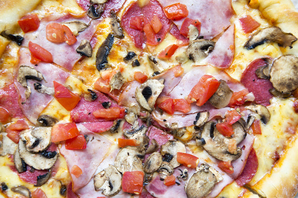 Freshly baked pizza with bacon, tomatoes, salami, cheese and mushrooms, closeup. Top view. - Fotoğraf, Görsel