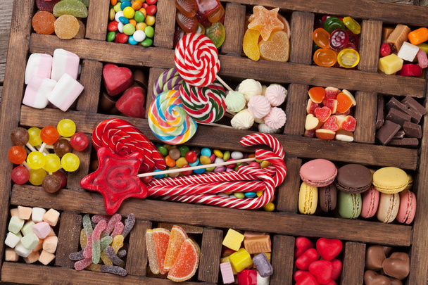Caixa de doces coloridos. Pirulitos, macaroons, marshmallow, marmelada e doces. Vista superior
 - Foto, Imagem