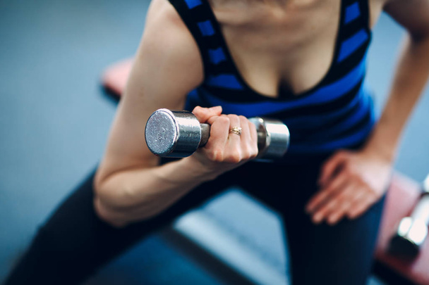 Jeune femme faisant du biceps. Fitness en salle de gym
. - Photo, image
