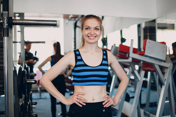 Mujer joven haciendo ejercicio. Imagen de retrato de la atractiva mujer en forma en el gimnasio. Retrato de cerca de chica atractiva en forma
. - Foto, imagen