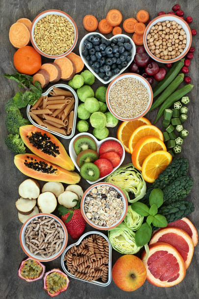 Υψηλή περιεκτικότητα σε ίνες τρόφιμα για την υγεία έννοια με ολόκληρα τα ζυμαρικά σίτου, όσπρια, σιτηρά, δημητριακά, φρέσκα φρούτα & λαχανικά στο μαρμάρινο παρασκήνιο κάτοψη. Τρόφιμα με υψηλή περιεκτικότητα σε ωμέγα 3, αντιοξειδωτικά & smart υδατάνθρακες. - Φωτογραφία, εικόνα