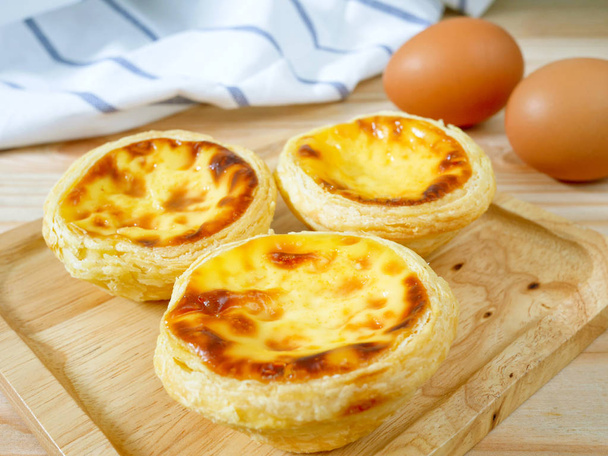 Fresh baked egg tarts or custard tarts (pastel de nata) on wooden plate - Photo, Image