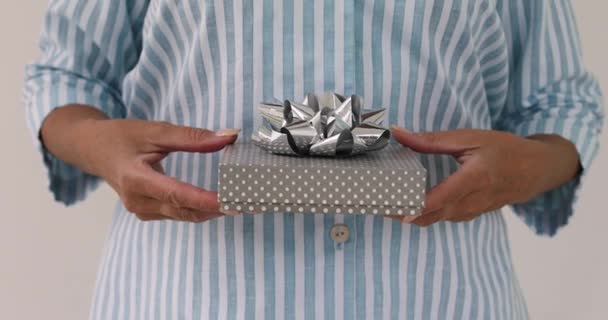 Женские руки дарят подарок в коробке с луком
 - Кадры, видео