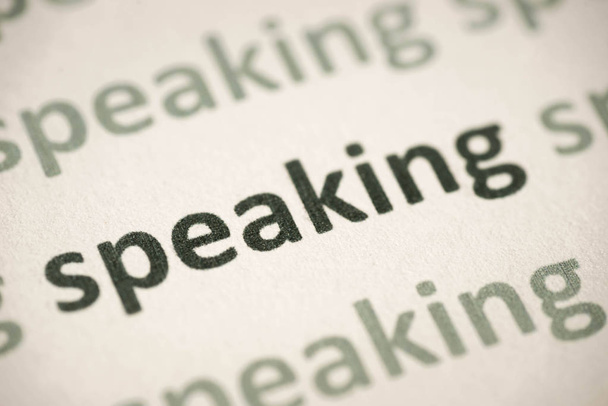 word speaking printed on white paper macro - Foto, Imagem