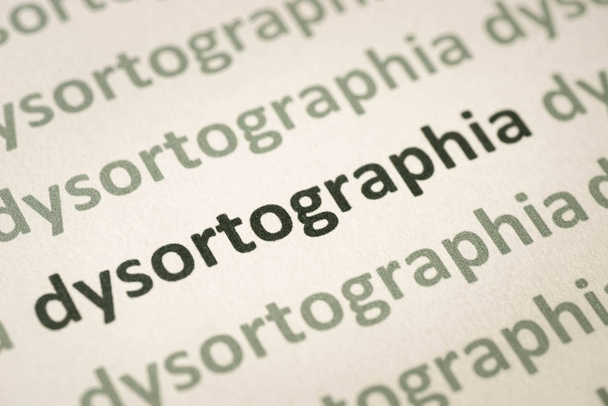 Word dysortographia gedrukt op wit papier macro - Foto, afbeelding