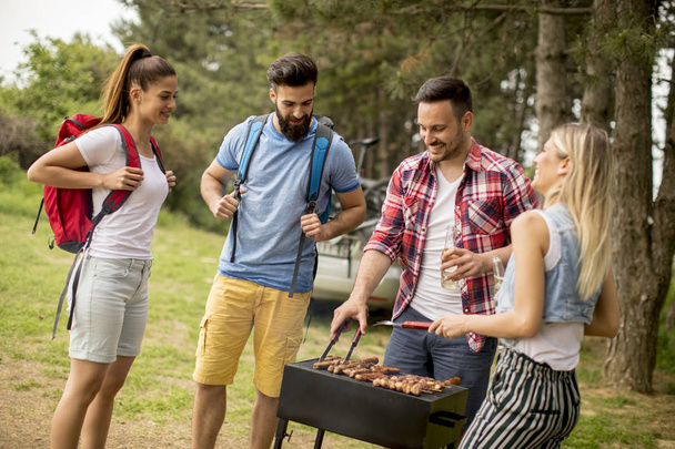 Groep jongeren genieten van barbecue partij in de natuur - Foto, afbeelding