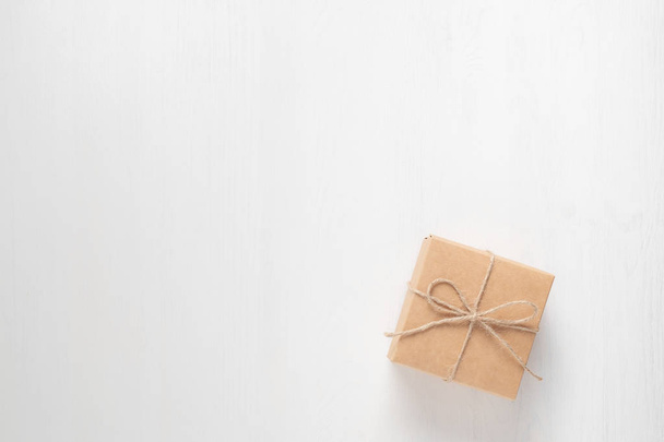 gift box tied with string on a white wooden background - Foto, immagini