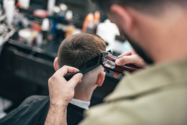 Mens haircut in barbershop. Hair Care. Barber cuts the client. - Φωτογραφία, εικόνα