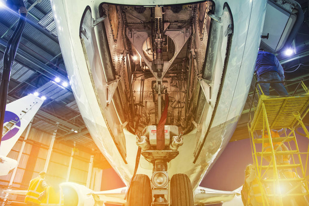 Передняя шасси пассажирского самолета крупным планом в ангаре на техническое обслуживание
 - Фото, изображение