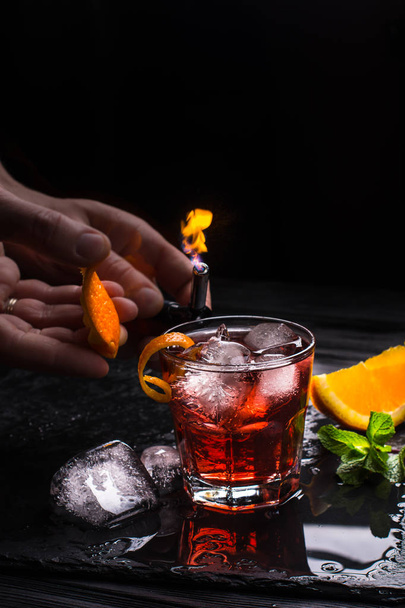 Cocktail Mezcal Negroni. Aperitivo italiano fumegante. Casca de laranja flamejada
. - Foto, Imagem