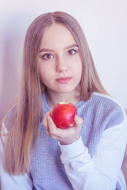The girl is giving an apple with a bitten edge - Foto, immagini