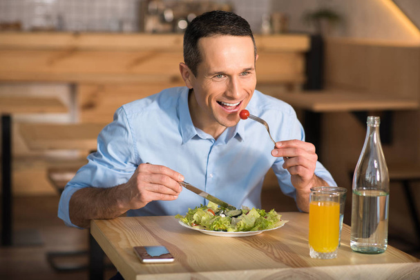 Portrait of happy businessman eating salad in cafe - Фото, изображение
