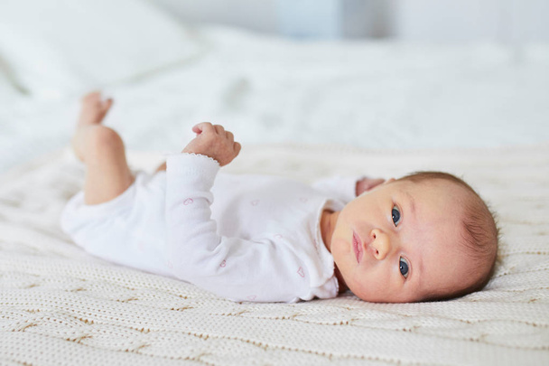 Adorable baby girl lying on bed in nursery - Foto, imagen