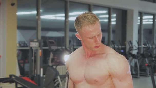 Ένας άνθρωπος είναι προπόνησης με βάρη στο γυμναστήριο - Πλάνα, βίντεο