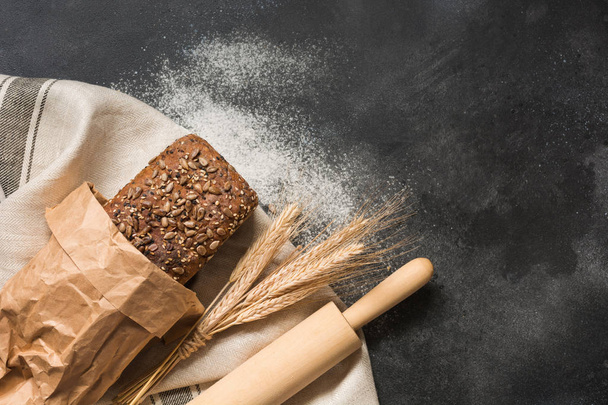 Homemade rye bread with sunflower seeds on dark rural food background. Top view. Space for text. - Photo, Image