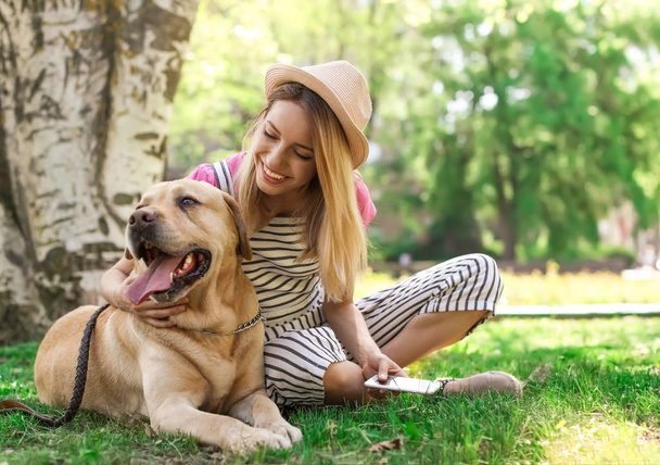 Young woman and her dog spending time together outdoors. Pet care - Fotó, kép