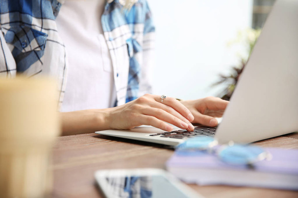 Молода жінка працює з ноутбуком за столом, крупним планом
 - Фото, зображення