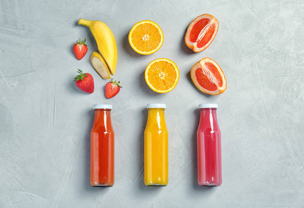 Flat lay composition with tasty juices and ingredients on light background - Foto, afbeelding