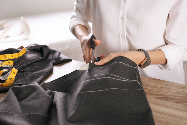 Tailor working with cloth at table in atelier - Foto, Imagem