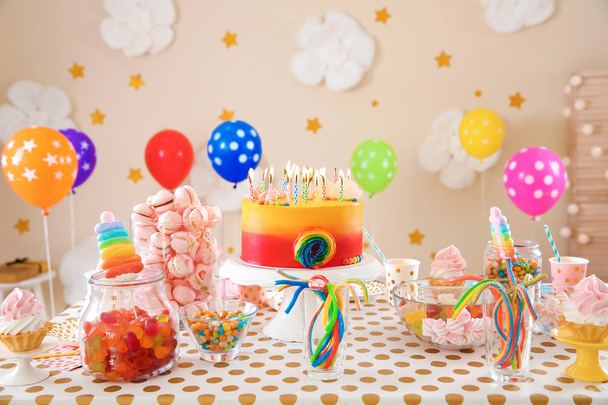 Table with birthday cake and delicious treats indoors - 写真・画像