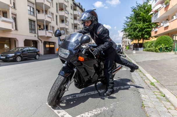 Una donna sale su una moto nera
 - Foto, immagini