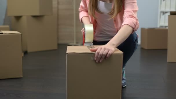 Lady from moving service carefully packing boxes with stuff and carrying out - Séquence, vidéo