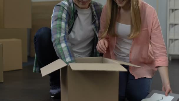 Couple in love moving in together, happy family unpacking boxes in new apartment - Záběry, video