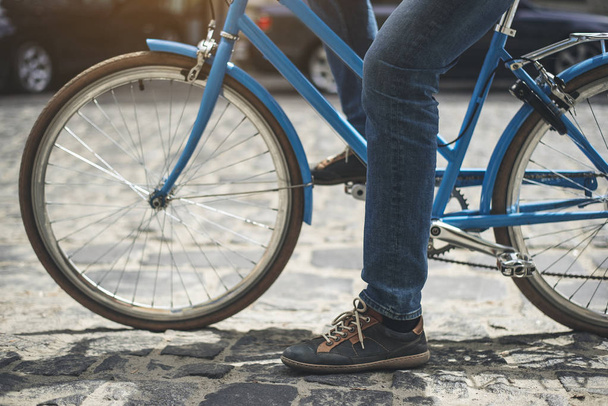 Male feet pedaling bike outside - Foto, afbeelding
