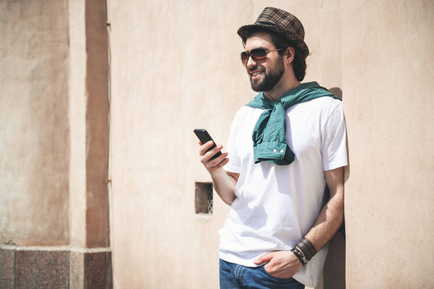 Attractive male person enjoying usage of his phone outdoors - 写真・画像