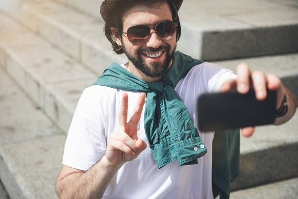 Trendy man maken grappige selfie - Foto, afbeelding