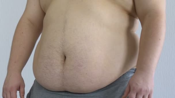 Smutný muž kontrola jeho tuk tělo dotýká žaludek, strie a celulitidu - Záběry, video