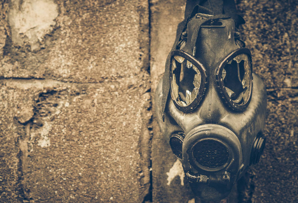 Masque à gaz cassé accroché au mur / Concept d'arme chimique toxique
 - Photo, image