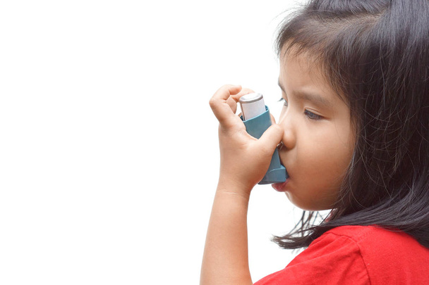Une fille utilisant un spray de traitement pour traiter l'asthme et les problèmes respiratoires isolés
  - Photo, image