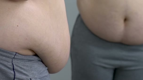 Big man putting white shirt on fat stomach, lack of sport activity, sickness - Кадри, відео