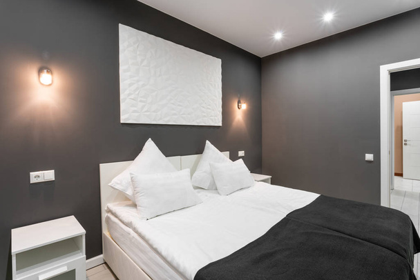 Hotel standart pokoju. Nowoczesna sypialnia z białym poduszki. proste i stylowe wnętrza. Oświetlenie wnętrza - Zdjęcie, obraz