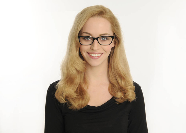 portrait d'une fille blonde portant une chemise noire et des lunettes, sur fond de studio blanc
. - Photo, image